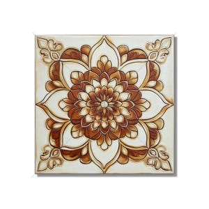 May include: A square ceramic tile with a brown and white floral design. The tile features a large, intricate flower in the center with a smaller flower in the middle. The tile has a raised, textured surface.