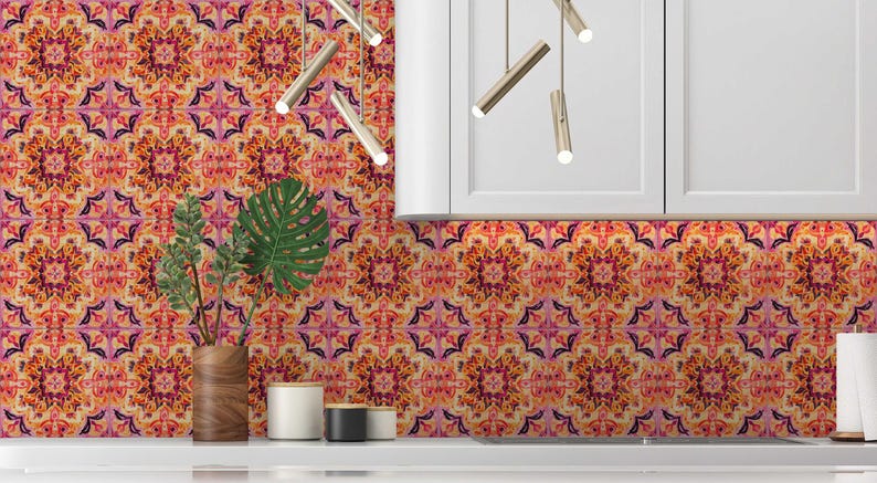 May include: A kitchen backsplash featuring a repeating floral pattern in orange, pink, and purple hues. The design resembles a mandala. A wooden vase with green leaves and a white countertop are in the foreground.