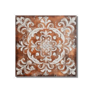 May include: Square wall art with a distressed copper-colored background and a white, ornate floral design. The design is centered and symmetrical, with a vintage, weathered appearance. The artwork is likely for home decor.