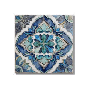 May include: Square ceramic tile with a symmetrical floral design in shades of blue, teal, and white. The raised pattern creates a textured appearance, with a central flower and surrounding stylized leaves.