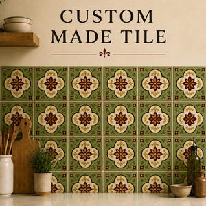 May include: A wall installation of square ceramic tiles featuring a repeating pattern of cream-colored quatrefoil shapes with dark red floral centers on a sage green background. The text CUSTOM MADE TILE is printed in black above the tile arrangement.