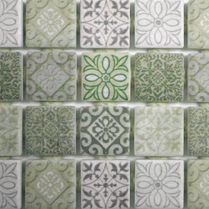 May include: A close-up of a green and white mosaic tile sheet with a variety of geometric patterns. The tiles are arranged in a grid pattern and have a slightly distressed look.