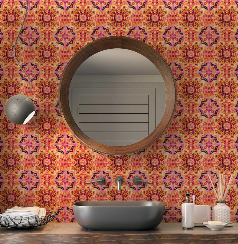 May include: A bathroom with a round wooden mirror, a dark grey oval sink, and wallpaper with a repeating floral pattern in orange, pink, and purple. A grey light fixture hangs from the ceiling. The wallpaper is the focal point.