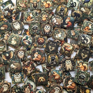 May include: A collection of small, square wooden tiles with detailed illustrations of woodland animals, including foxes, owls, bears, and raccoons. The tiles feature a vintage, botanical style with earthy tones and intricate floral borders.
