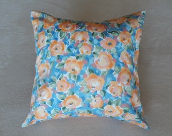 May include: A blue and orange floral patterned throw pillow. The pillow is made of a soft fabric and has a subtle sheen.