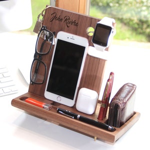 May include: A wooden desk organizer with compartments for a phone, watch, keys, glasses, pens, and a wallet. The organizer is personalized with the name "John Rivera".