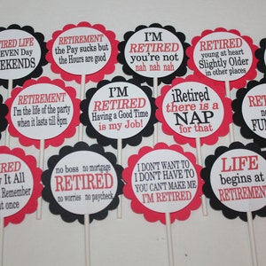 May include: A collection of retirement-themed party decorations. Each decoration is a round, scalloped-edged sign with a white center and red or black borders. Text in red and black font includes phrases like "Retired Life" and "I'm Retired."
