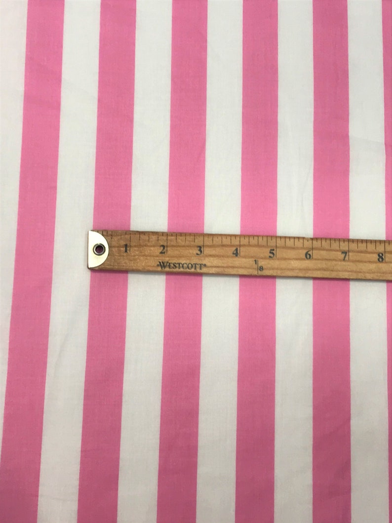 May include: Pink and white striped fabric with a ruler measuring 8 inches.