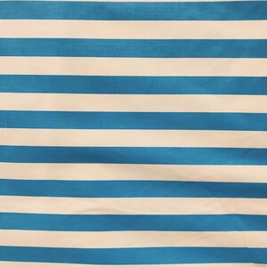 May include: A blue and white striped fabric with a subtle texture. The fabric is folded and has a slight wrinkle.