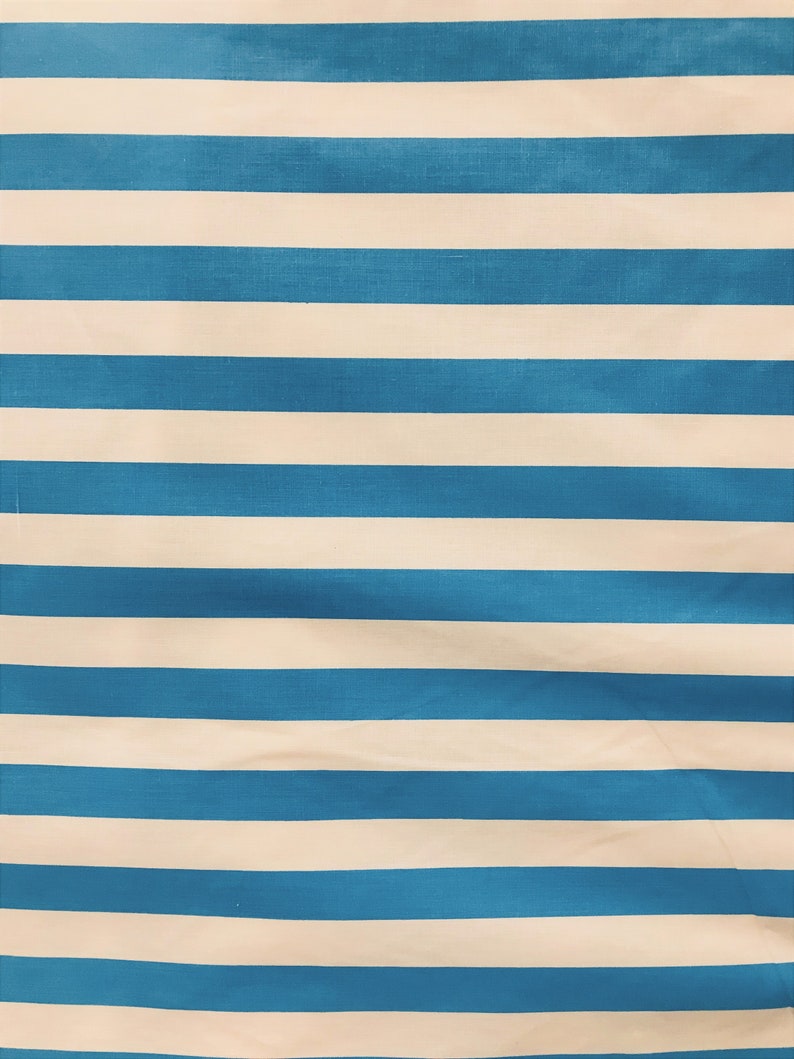 May include: A blue and white striped fabric with a subtle texture. The fabric is folded and has a slight wrinkle.