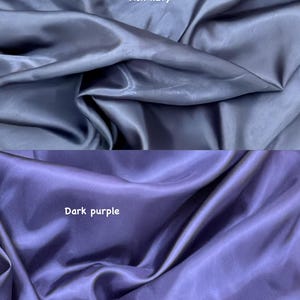 Puede incluir: Dos secciones de tela, una azul marino ceniza y otra morada oscura. Las telas tienen un brillo sedoso, satinado, con pliegues y arrugas visibles. El texto "Ash navy" y "Dark purple" son visibles.