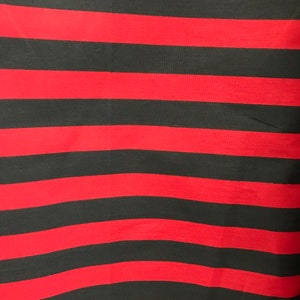 May include: Red and black striped fabric. The fabric has horizontal stripes.