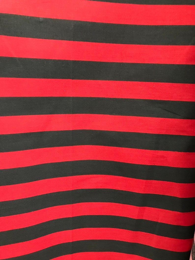 May include: Red and black striped fabric. The fabric has horizontal stripes.