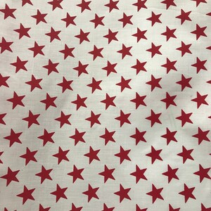 May include: White fabric with a repeating pattern of red stars.