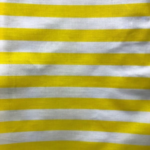 May include: Yellow and white striped fabric with a subtle texture. The fabric is folded and has a slight wave pattern.