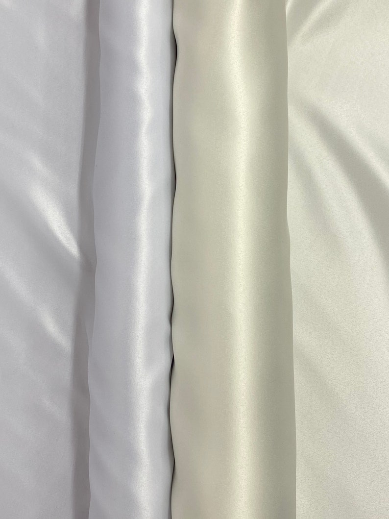 May include: Three rolls of white satin fabric, each with a slightly different shade of white.