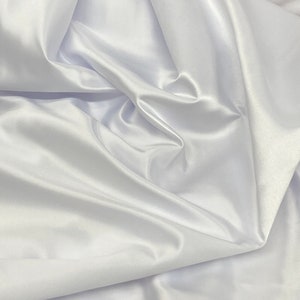 May include: White satin fabric with soft, flowing folds and a smooth, luxurious texture.