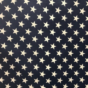 May include: A navy blue fabric with a repeating pattern of white stars. The stars are arranged in diagonal rows.