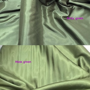 Puede incluir: Primer plano de dos secciones de tela verde oliva. La secci&oacute;n superior est&aacute; etiquetada como "Army green" y la secci&oacute;n inferior como "Moss green". La tela tiene un aspecto brillante y sedoso con pliegues y arrugas suaves.