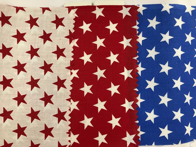 May include: Three fabric swatches with a white star pattern on different colored backgrounds. The swatches are white with red stars, red with white stars, and blue with white stars.