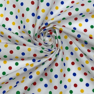 May include: White fabric with a repeating pattern of colourful polka dots. The dots are red, yellow, blue, and green.