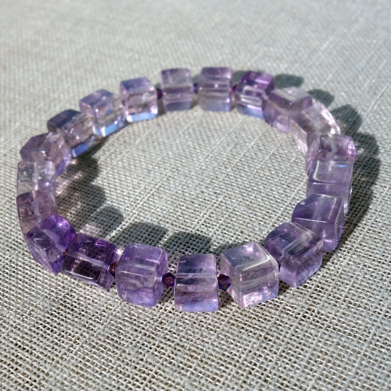 May include: A purple amethyst gemstone bracelet with square-shaped beads.