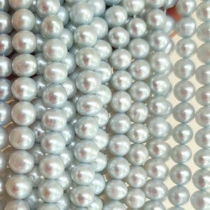 May include: A strand of light blue freshwater pearls. The pearls are round and smooth, with a high lustre.