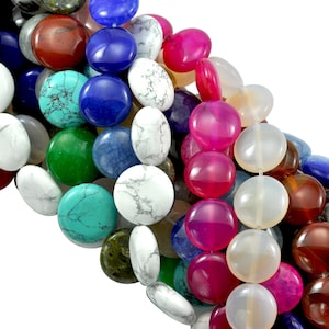 May include: A close-up of a strand of round, flat gemstone beads in various colours, including white, blue, green, red, and pink. The beads are arranged in a random pattern, creating a visually appealing and colourful display.