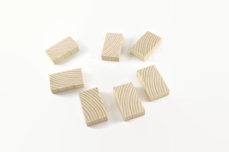 May include: Eight wooden dominoes with a light brown color and a wood grain pattern. The dominoes are arranged in a circle on a white surface.