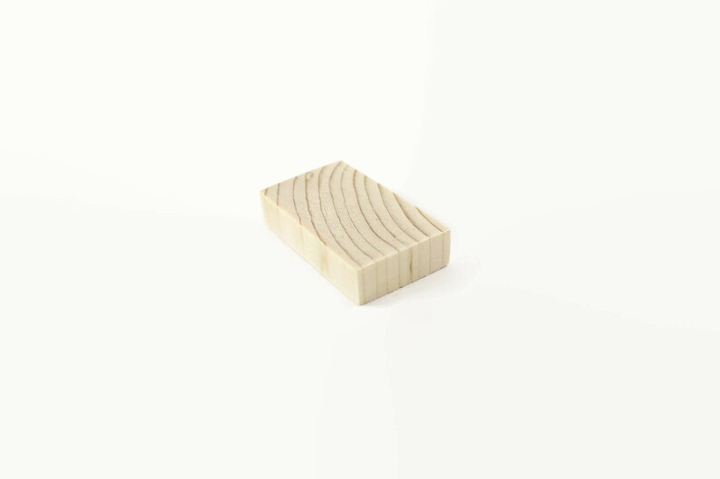 May include: A light brown wooden block with a natural wood grain pattern.