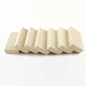May include: Seven wooden blocks stacked in a staggered pattern, creating a staircase effect. The blocks are light brown and have a natural wood grain.