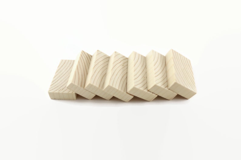 May include: Seven wooden blocks stacked in a staggered pattern, creating a staircase effect. The blocks are light brown and have a natural wood grain.