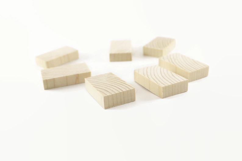 May include: Seven wooden blocks arranged in a circle on a white background. The blocks are all the same size and shape, and they are made of a light-colored wood. The blocks have a natural wood grain pattern.