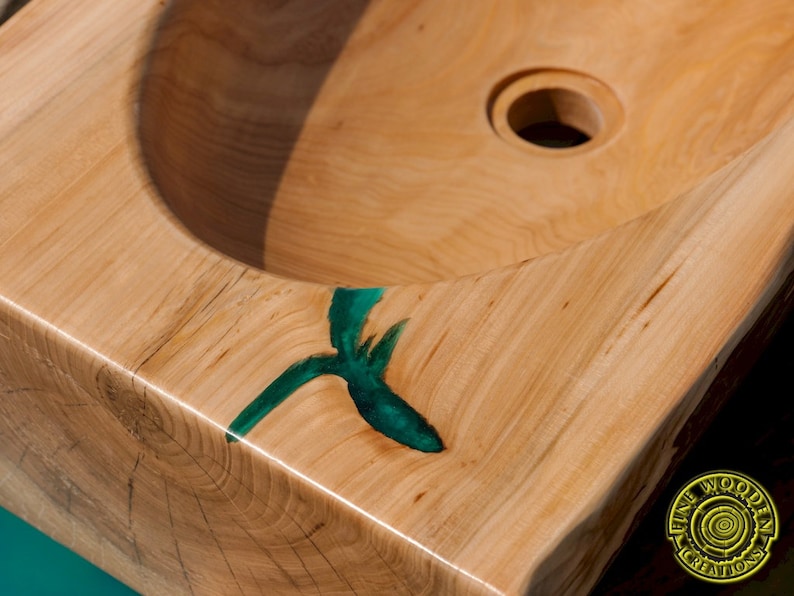 K&ouml;nnte beinhalten: Ein Waschbecken aus Holz mit einem gr&uuml;nen Epoxidharzeinleger. Das Waschbecken ist aus einem einzigen St&uuml;ck Holz gefertigt und hat ein nat&uuml;rliches, rustikales Aussehen. Das Waschbecken ist f&uuml;r die Verwendung in einem Badezimmer oder einer K&uuml;che konzipiert.