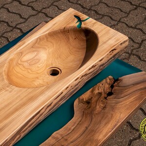 K&ouml;nnte beinhalten: Eine Holztheke mit einem ausgeh&ouml;hlten Waschbecken und einer Einlage aus t&uuml;rkisfarbenem Epoxidharz. Die Arbeitsplatte besteht aus einem einzigen St&uuml;ck Holz mit nat&uuml;rlichen Kanten und einer Live-Edge-Oberfl&auml;che.
