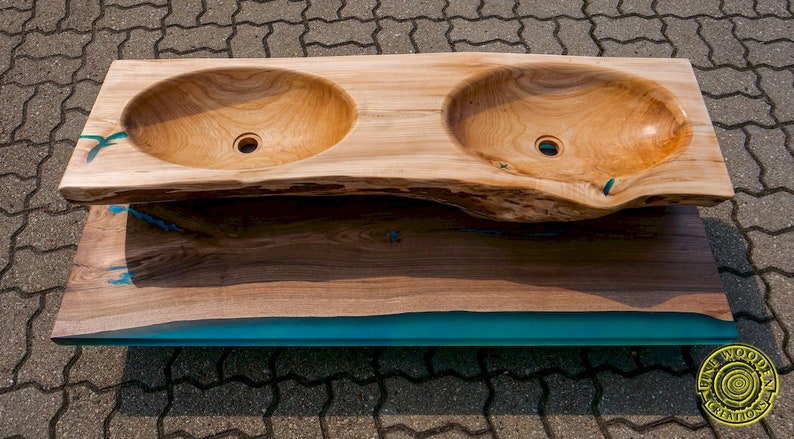 K&ouml;nnte beinhalten: Doppelwaschtisch aus einer gro&szlig;en Holzplatte mit einem t&uuml;rkisfarbenen Harzeinleger. Die Waschbecken sind aus dem Holz geschnitzt und haben eine nat&uuml;rliche Oberfl&auml;che.