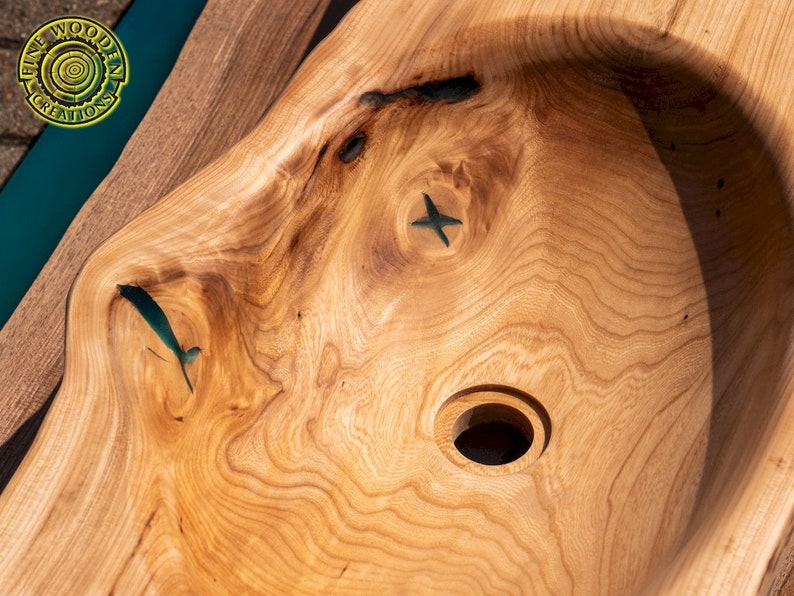 K&ouml;nnte beinhalten: Nahaufnahme eines Waschbeckens aus Holz mit einer Einlage aus t&uuml;rkisfarbenem Harz. Das Waschbecken hat eine runde Form mit einem Loch in der Mitte f&uuml;r einen Abfluss.