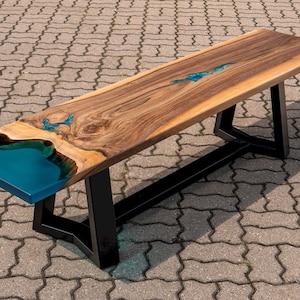 Epoxy resin bench for dining table with turquoise glowing pigment, walnut wood, turquoise/blue resin