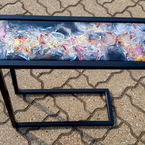 Resin cast end table on metal C shaped legs, abstract design, blue , red, gold, white