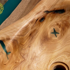 K&ouml;nnte beinhalten: Ein Waschbecken aus Holz mit einer nat&uuml;rlichen Holzmaserung. Das Waschbecken hat eine einzigartige Form und verf&uuml;gt &uuml;ber zwei kleine gr&uuml;ne Epoxidharz-Einlagen.