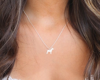 May include: A silver necklace with a small, detailed dog silhouette pendant.