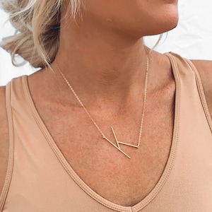 以下が含まれることがあります： シンプルな幾何学的なKの文字のペンダントが付いたゴールドチェーンネックレス