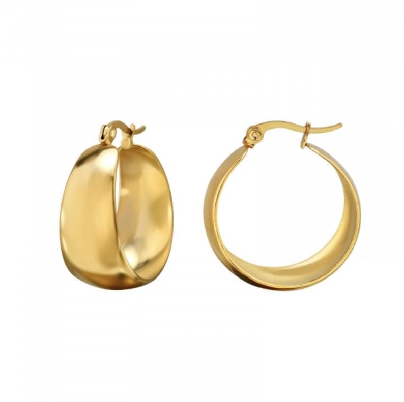 May include: Two gold-colored hoop earrings. One earring is a rounded, oval shape, while the other is a classic hoop design. Both earrings have a shiny, polished finish, reflecting light. The earrings are set against a white background.