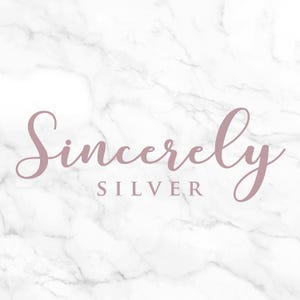 K&ouml;nnte beinhalten: Ein Marmorhintergrund mit den Worten "Sincerely SILVER" in einer mauvefarbenen Schrift. Das Wort "Sincerely" ist kursiv geschrieben, w&auml;hrend "SILVER" eine serifenlose Schriftart hat.