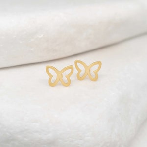 May include: A pair of gold butterfly earrings. The earrings are small and delicate, and they are perfect for adding a touch of elegance to any outfit.