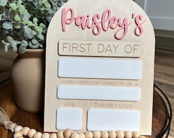 Puede incluir: Letrero de madera con letras rosas que dice "Paisley's FIRST DAY OF". Incluye espacio para escribir "WHEN I GROW UP I WANT TO BE A", "AGE" y "THINGS I LOVE".