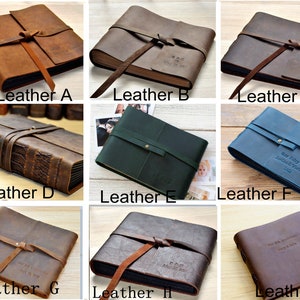 May include: Nine different leather-bound photo albums with various colors and styles. Each album has a leather strap and a personalized inscription.