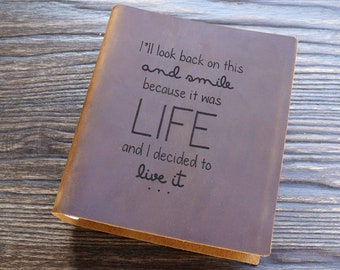 May include: A brown leather journal with the text "I'll look back on this and smile because it was LIFE and I decided to live it..." embossed on the cover.