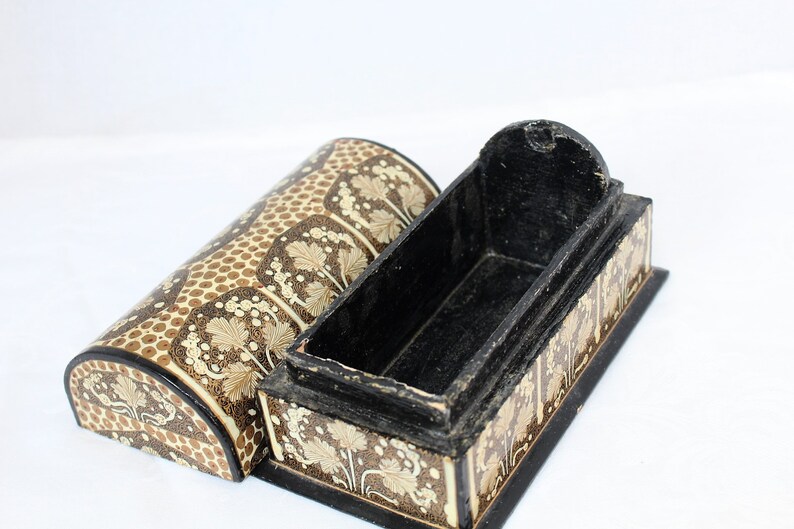 May include: An open, decorative wooden box with a matching lid. The box and lid are painted with a repeating pattern of beige leaves and brown dots on a cream background. The interior of the box is black.