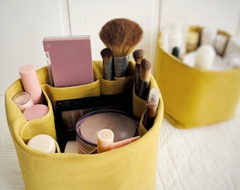 Organic cotton skincare organizer/makeup caddy with inner pockets that  protect glass and hood items upright.  Skin care product organizer